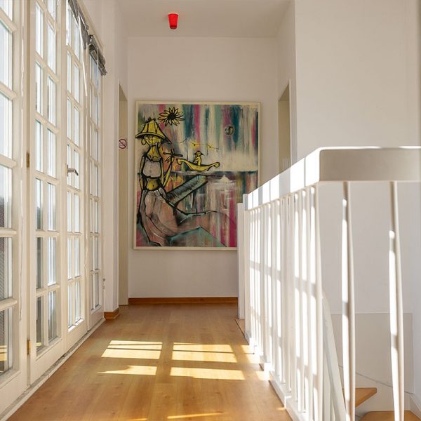 Flur in einer Bonner Immobilie zum Verkauf mit französischen Fenstern und modernem Kunstwerk