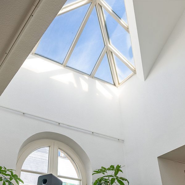 Helles Dachfenster in Bonner Wohnung zum Verkauf, das Tageslicht in einen hohen Raum strömen lässt
